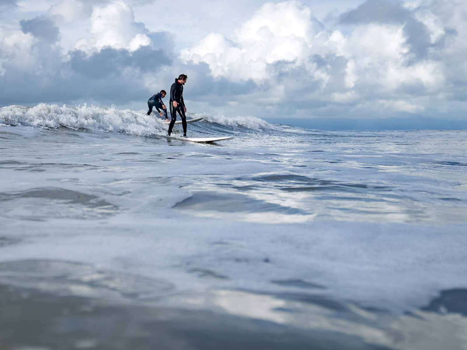 Yakutat Surf Club member Jackson Wolfe stands up on his first glassy wave with surf mentor Kanaan Bausler. Yakutat, Alaska. Photo: Chelsea Jolly