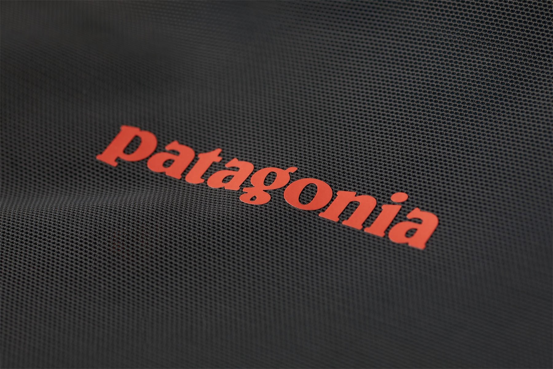 Close-up of the lightweight mesh material and Patagonia logo on the PSI Vest 2.0.